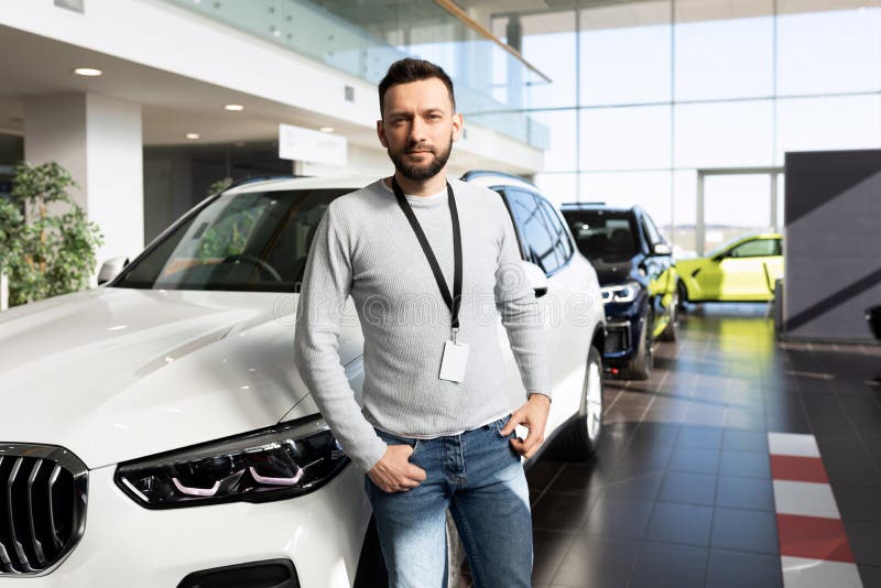 Serious Seller in a Car Dealership Next To the Car Stock Image Image