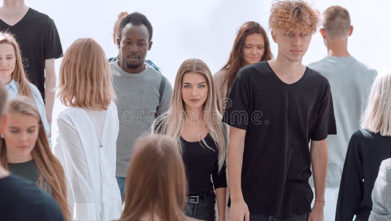 Serious woman standing in front of casual group of young people stock image