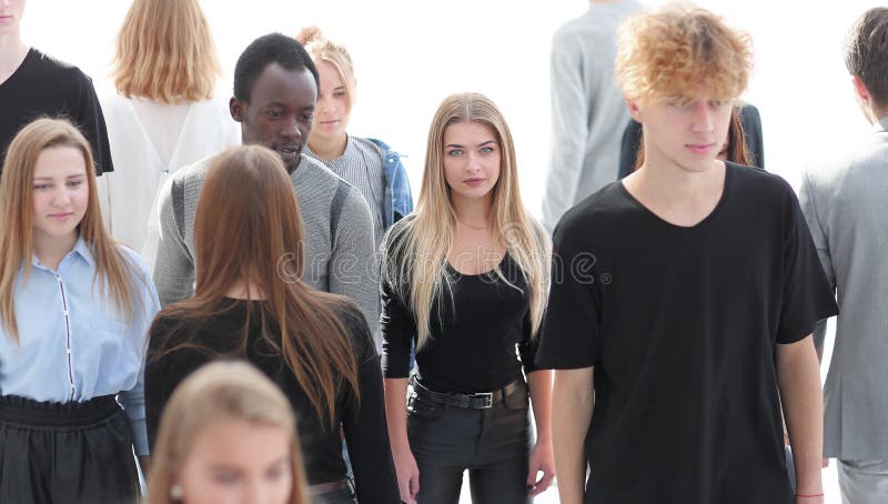 Serious woman standing in front of casual group of young people stock photo