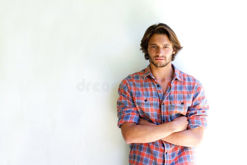 Serious young man with arms crossed on white background