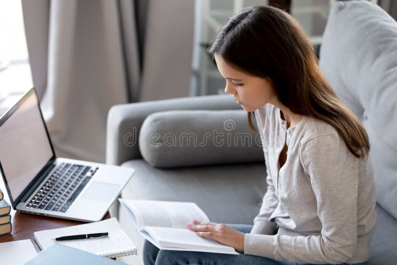 Serious young woman preparing to passing exam or doing homework