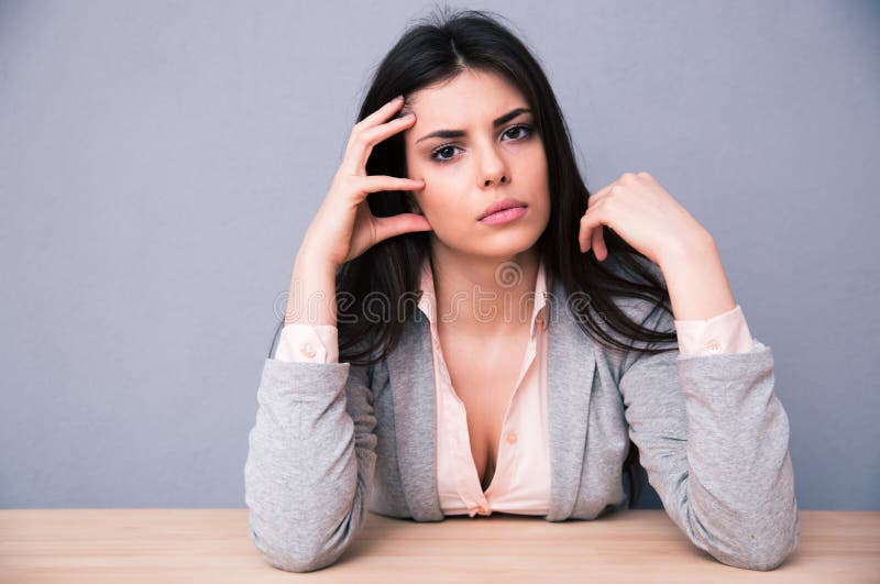 Serious young woman sitting at the table