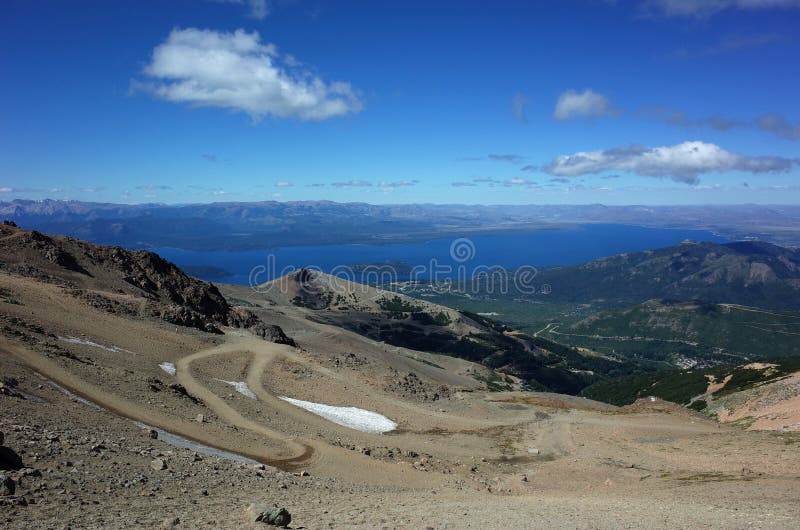 Serpentine dirt road on mountainside of Cerro Catedral mountain with view of Nahuel Huapi lake in Nahuel Huapi National Park