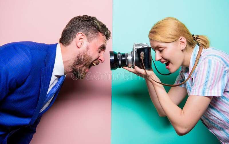 Serrage de son expression de visage Jolie femme ? l'aide de la cam?ra professionnelle Mod?le masculin de tir de photographe dans images libres de droits Serrage de son expression de visage Jolie femme ? l'aide de la cam?ra professionnelle Mod?le masculin de tir de photographe dans images libres de droits