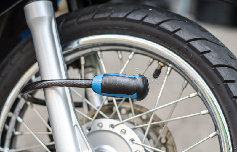 Serratura di sicurezza che blocca la ruota anteriore del motociclo fotografie stock Serratura di sicurezza che blocca la ruota anteriore del motociclo fotografie stock