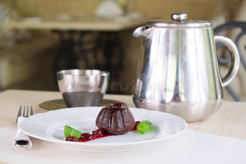 Served table with a muffin, a coffee pot and a cup