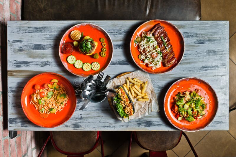 Served table with various dishes of the restaurant. Hot dog, barbecue pork ribs, steak, Carbonara paste and crab salad stock photos Served table with various dishes of the restaurant. Hot dog, barbecue pork ribs, steak, Carbonara paste and crab salad stock photos