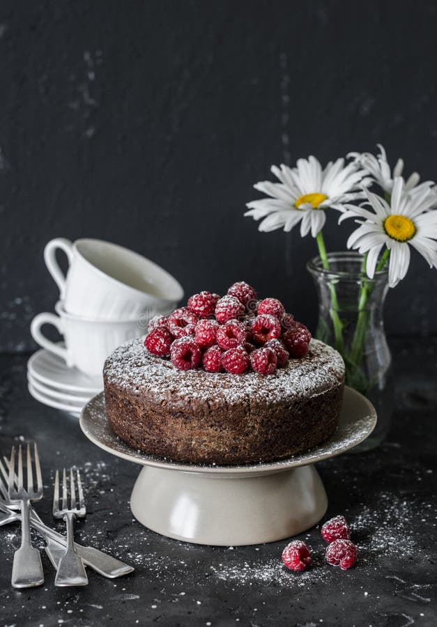 Served tea table still life - chocolate nut cake with raspberry on a dark background. Delicious dessert.Flat lay royalty free stock image Served tea table still life - chocolate nut cake with raspberry on a dark background. Delicious dessert.Flat lay royalty free stock image