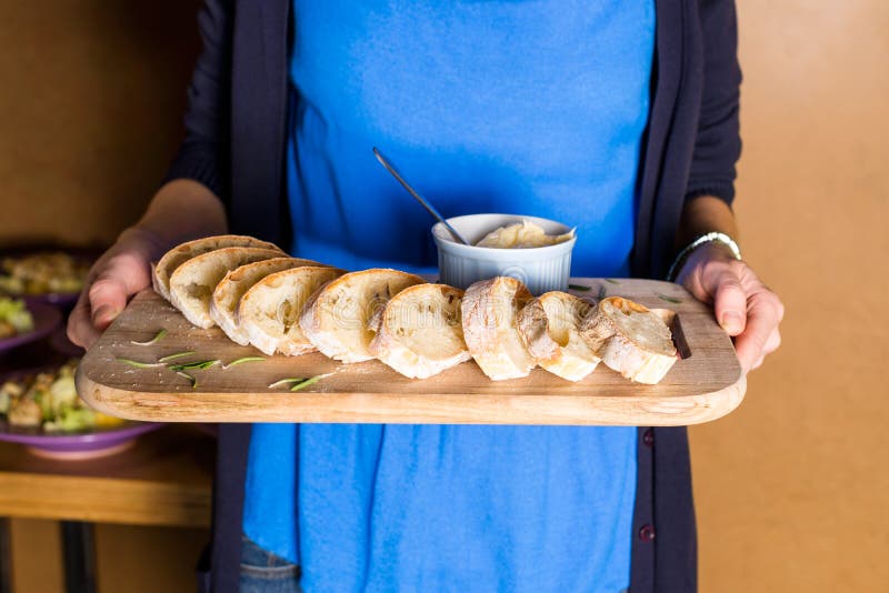 Server holding wooden tray with freshly baked bread and homemade butter. Women's hands with wooden server of appetizers. stock photos Server holding wooden tray with freshly baked bread and homemade butter. Women's hands with wooden server of appetizers. stock photos