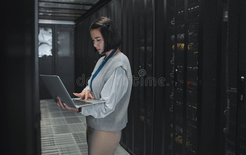 Server room, laptop and technician woman for data center management, system update and cyber security. Focus, serious stock images