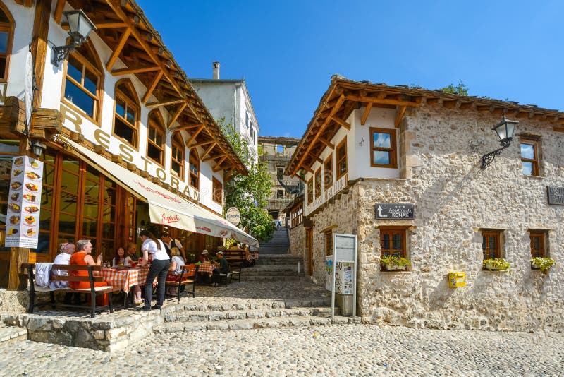 A server takes an order from a table of tourists in the old town center of the medieval city of Mostar, Bosnia and Herzegovina. stock photography A server takes an order from a table of tourists in the old town center of the medieval city of Mostar, Bosnia and Herzegovina. stock photography