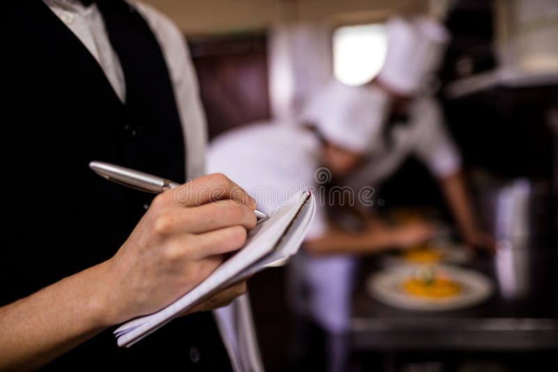 Serveur ou avec le bloc-notes prend une commande dans le restaurant Photo  Stock - Alamy