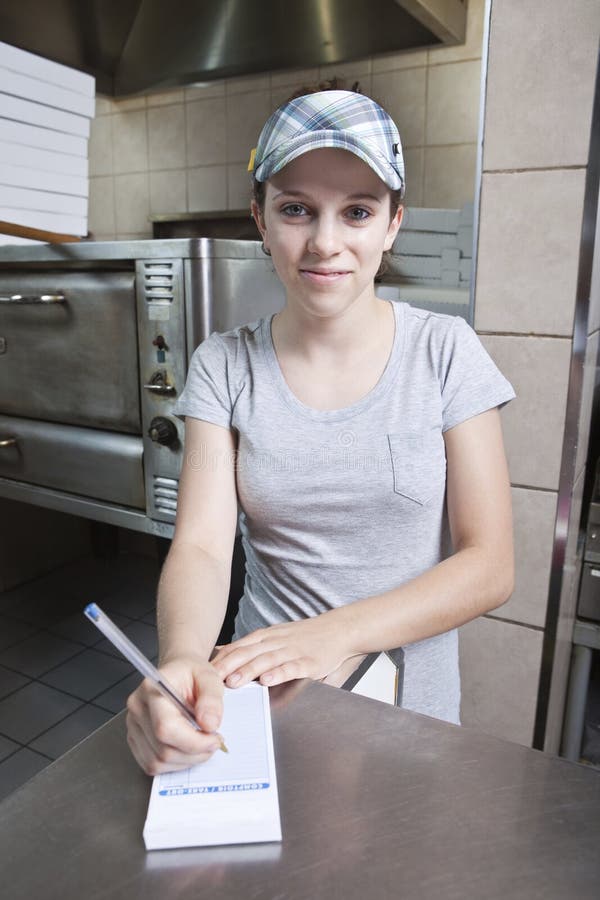 Serveuse prenant la commande dans un restaurant d'aliments de préparation rapide photo stock Serveuse prenant la commande dans un restaurant d'aliments de préparation rapide photo stock