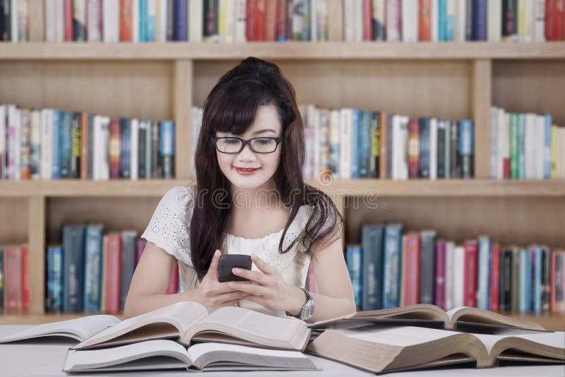 Service de mini-messages d'étudiant dans la bibliothèque images stock