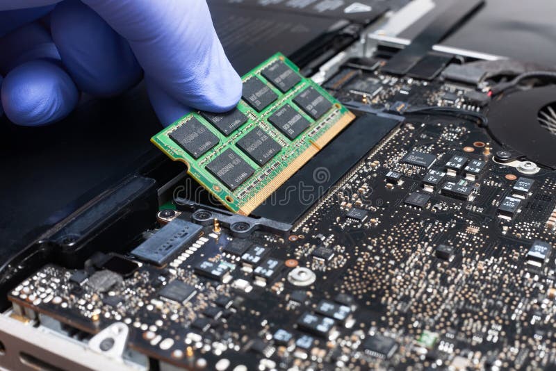 Service engineer install new RAM memory chips to the laptop. Repairing and upgrading laptop concept. Close up view