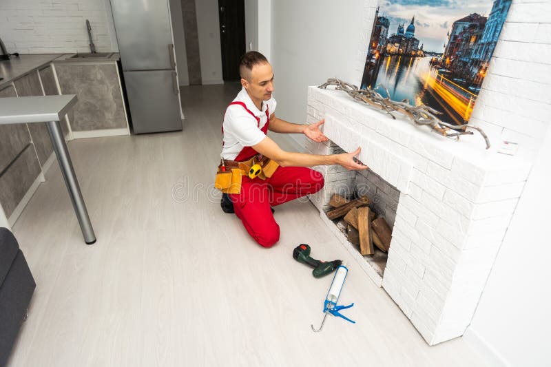 Service Technician Repairing a Fireplace in a Home Stock Photo Image