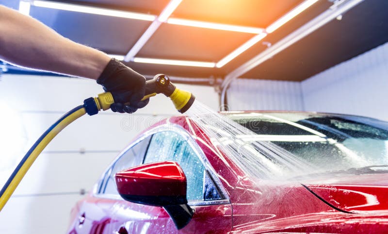 Service worker washing car on a car wash.