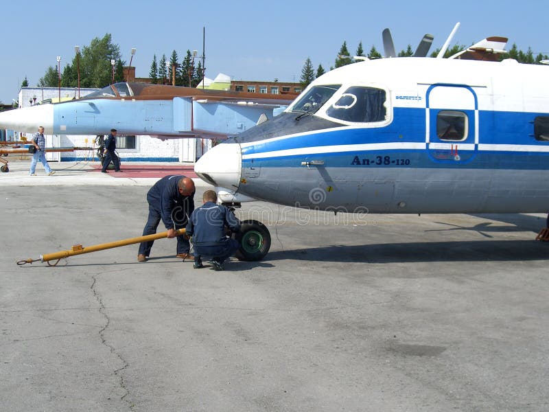 Servicio del Antonov ruso an-38 en los trabajadores del técnico del campo de aviación imagenes de archivo Servicio del Antonov ruso an-38 en los trabajadores del técnico del campo de aviación imagenes de archivo