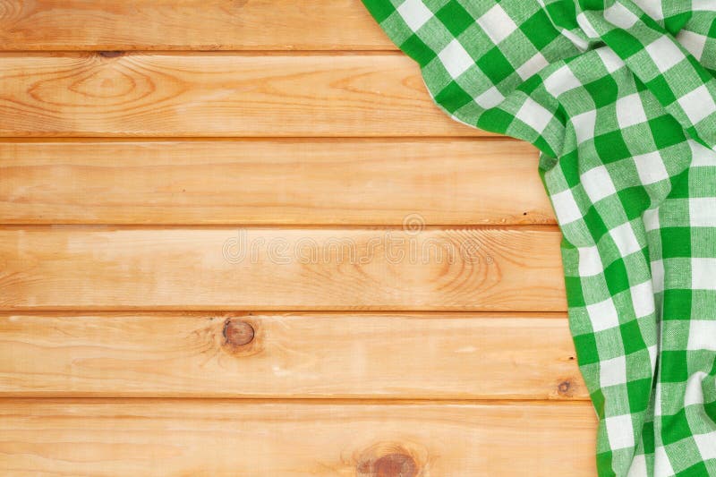 Green towel over wooden kitchen table. View from above with copy space. Green towel over wooden kitchen table. View from above with copy space