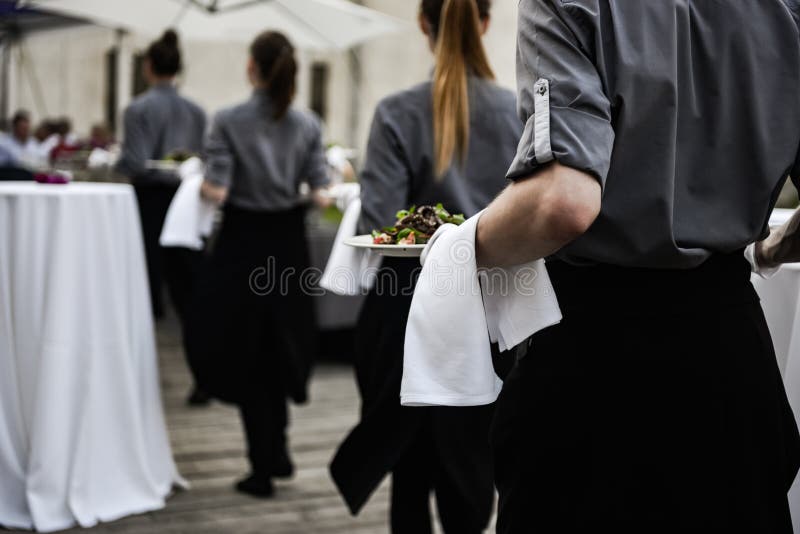 Servitrins bär plattor av mat arkivbilder Servitrins bär plattor av mat arkivbilder