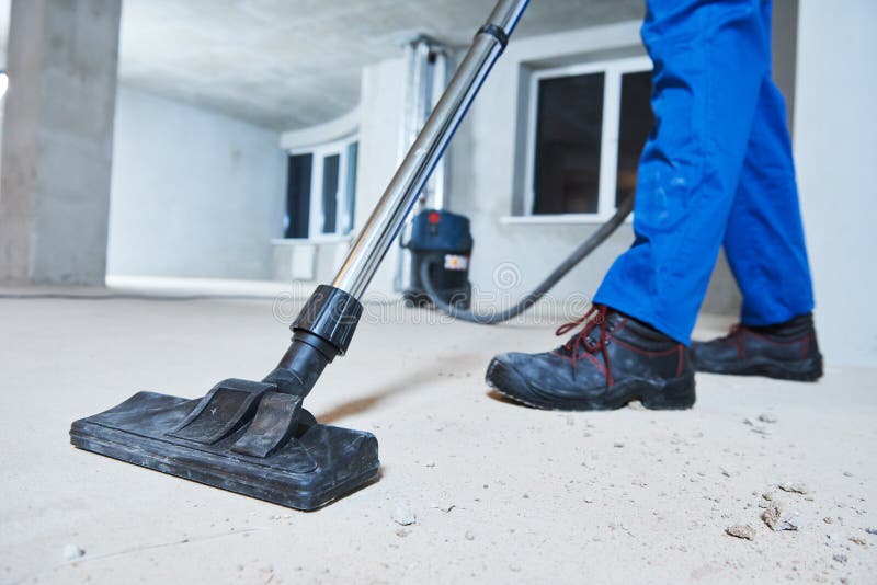 Young woman cleaning and removing construction dust with vacuum cleaner after repair. Young woman cleaning and removing construction dust with vacuum cleaner after repair