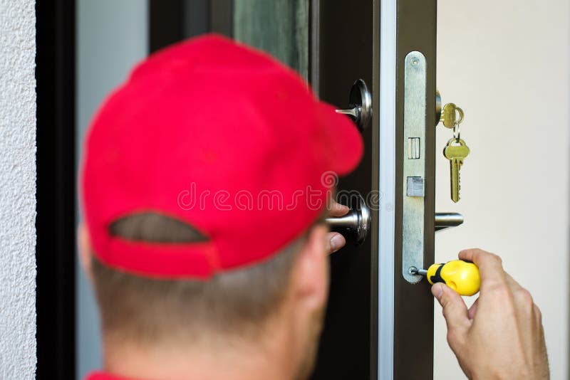 Serviço da fechadura da porta - serralheiro que trabalha com chave de fenda imagens de stock royalty free Serviço da fechadura da porta - serralheiro que trabalha com chave de fenda imagens de stock royalty free