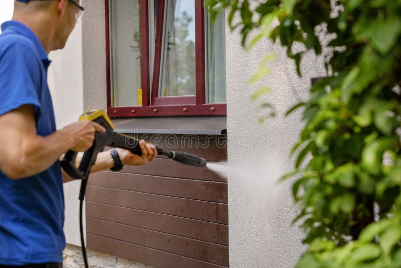 Serviço de limpeza da fachada da casa parede da lavagem do homem com arruela de alta pressão