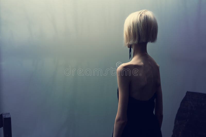 Sessione di foto dal lago un giorno nebbioso nella foresta, ragazza scarna in vestito nero fotografia stock Sessione di foto dal lago un giorno nebbioso nella foresta, ragazza scarna in vestito nero fotografia stock