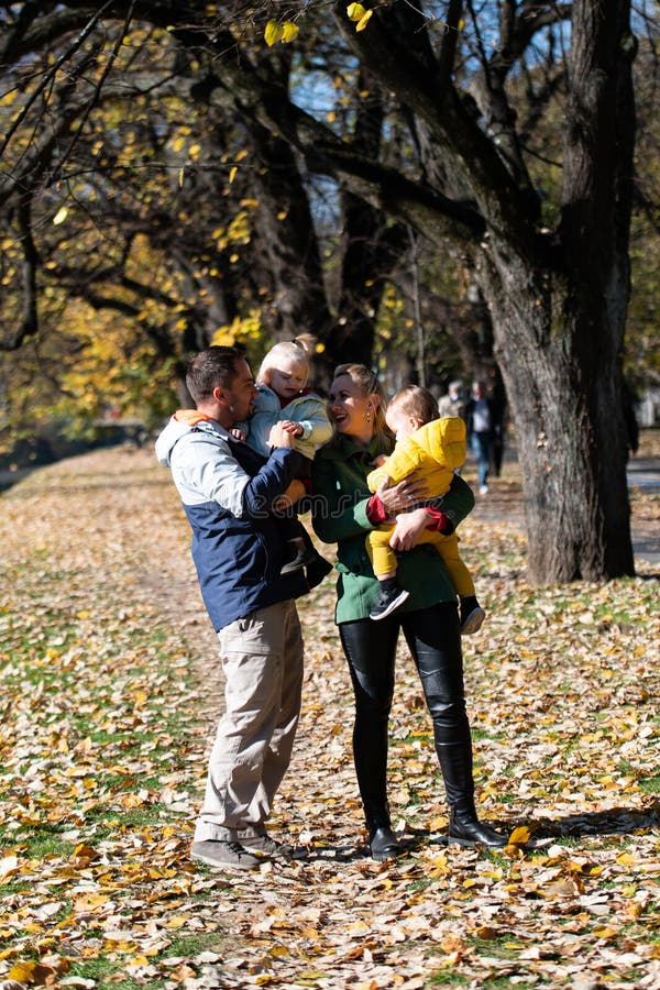 Sessione di ritratti familiari sotto alberi d'oro caduti fotografia stock