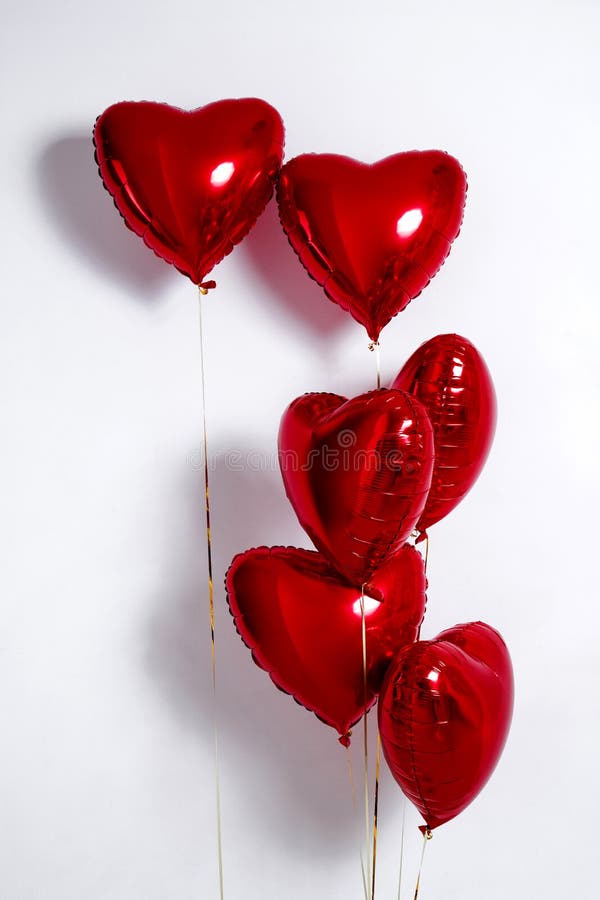 Set of Air Balloons. Bunch of red color heart shaped foil balloons isolated on white background.