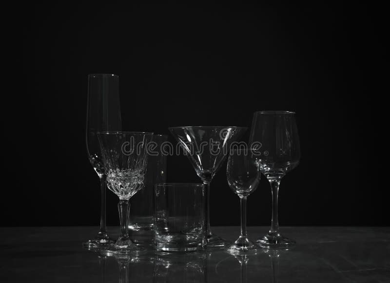 Set of Bar Glassware on Table Against Dark Background Stock Image