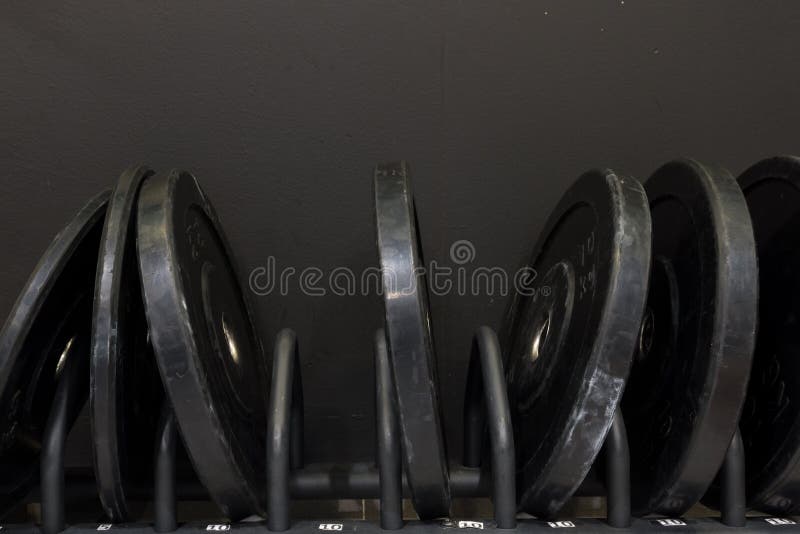 Set of big metal weights on a rack in a gym with dark grey, black background royalty free stock photo Set of big metal weights on a rack in a gym with dark grey, black background royalty free stock photo