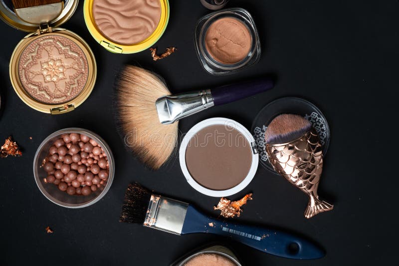 Set of Bronze Powder with Makeup Brushes on Black Background Stock