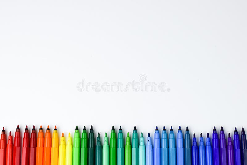 A set of colored markers without caps, arranged on a white background in the order of the colors of the rainbow stock images