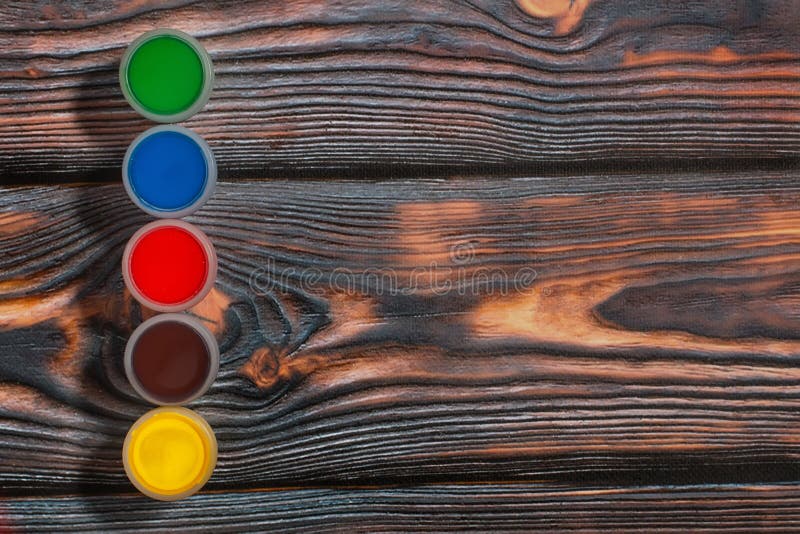 Set of Colorful Finger Paint Jars on a Rustic Background Stock Image