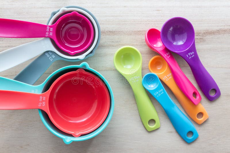 Set of colorful measuring cups and measuring spoons use in cooking. Set of colorful measuring cups and measuring spoons use in cooking lay on wood tabletop in