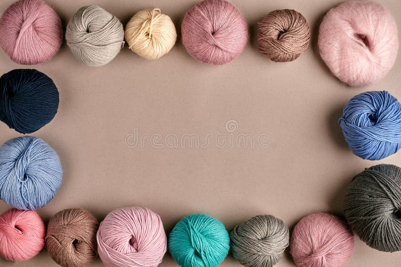 Set of colorful wool yarn on beige background. Knitting as a kind of needlework. Colorful balls of yarn and knitting needles. Top view. Still life. Copy space. Flat lay. Frame of tangles of knitting threads. Set of colorful wool yarn on beige background. Knitting as a kind of needlework. Colorful balls of yarn and knitting needles. Top view. Still life. Copy space. Flat lay. Frame of tangles of knitting threads