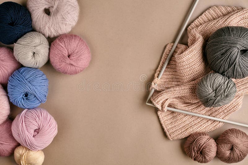 Knitting needles with threads, beige yarn. Hobby for women concept.  Knitting accessories Stock Photo by paralisart
