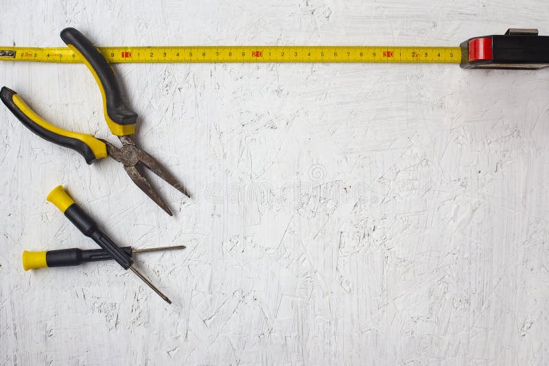 Set of construction tools lying on a white texture background.