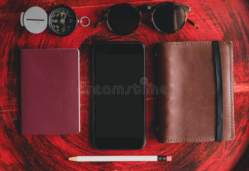 Set de ochelari de soare pentru notebook-uri mobile și creion alb pe masă rotundă din lemn rustic roșu în apropierea ferestrelor d royalty free stock images