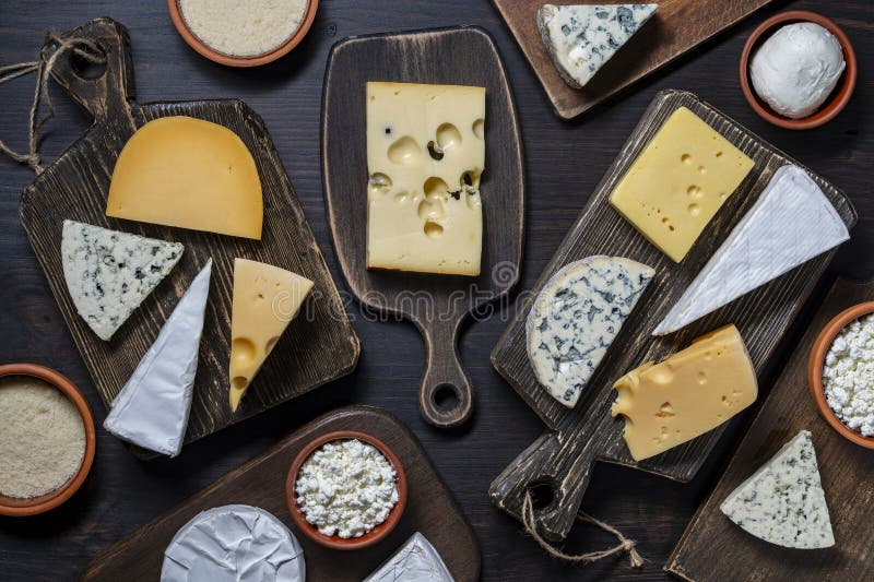 Set di formaggi diversi su tavolette di taglio in legno con vista superiore. Vari tipi di formaggio immagini stock