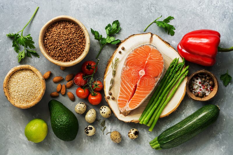 A set of healthy balanced super food, fresh salmon, vegetables, egg, cereals and nuts on a gray background. Top view, flat lay stock photography A set of healthy balanced super food, fresh salmon, vegetables, egg, cereals and nuts on a gray background. Top view, flat lay stock photography