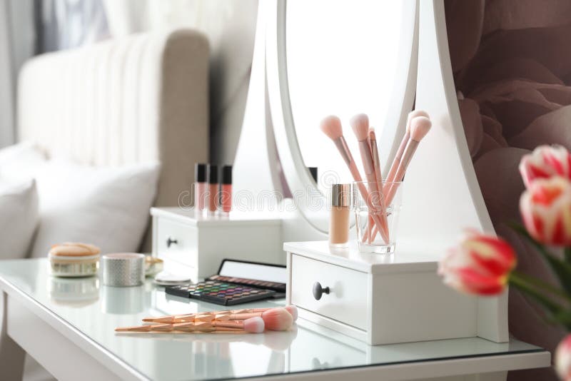 Set of Makeup Products and Cosmetic Brushes on Dressing Table. Interior