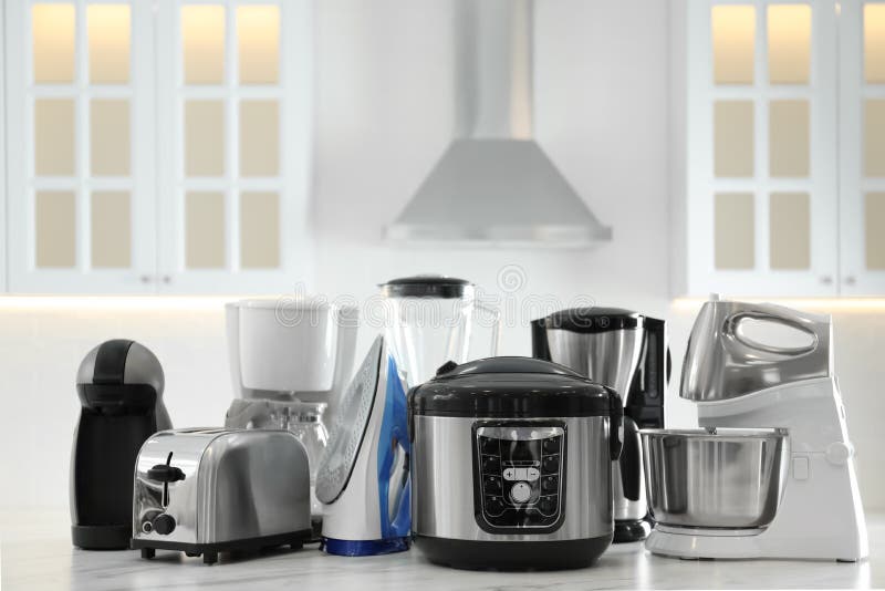Set of Modern Home Appliances on White Table in Kitchen Stock Photo