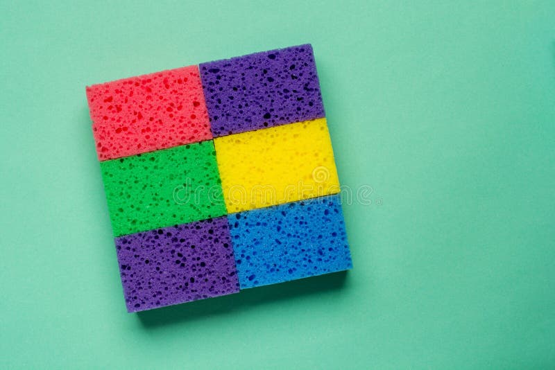 Set multi-colored sponges on a green background, space for text. Flat lay. Multi colored foam sponges stock images, royalty-free photos and pictures
