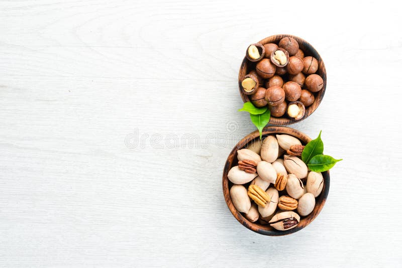 Set of Nuts. Pecans and Macadamia Nuts in Bowls on a White Background