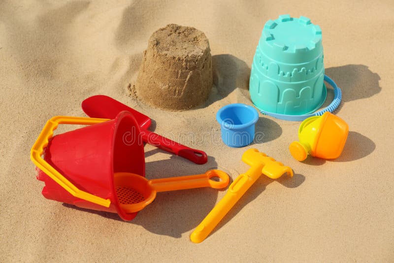 Set of Plastic Beach Toys and Flip Flops on Sand, Flat Lay. Outdoor