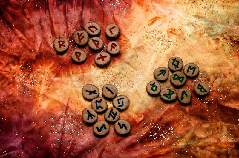Set of runes divided into aetts on mottled colorful fabric