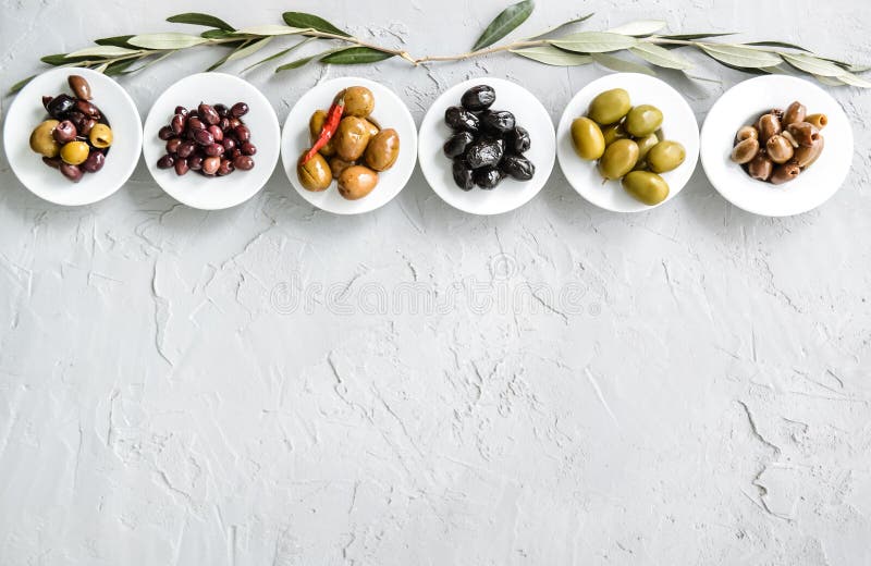 set of selected pickled olives in white bowls