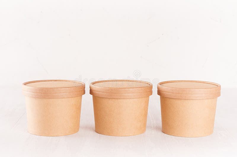 Set of three cardboard bowls with caps for fast food, soup or ice cream on white wood table, food branding identity mockup. royalty free stock photo Set of three cardboard bowls with caps for fast food, soup or ice cream on white wood table, food branding identity mockup. royalty free stock photo